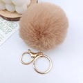 Nahaufnahme von khakifarbenem Plüsch-Pompon-Schlüsselanhänger mit goldenem Metallring - 8cm Kaninchenpelz-Imitat-Ball / Camel