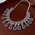Dettaglio della collana con pendente in zircone verde smeraldo su sfondo di seta rossa - Collana - Argento - Blu
