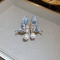 Elegant butterfly earrings with light blue inlay and pearls on a sleek grey tray - Silver Butterfly Pearl Style