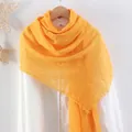 Bright yellow crinkled linen scarf with frayed edges hanging on a wooden hanger - Bright Yellow