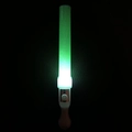 Close-up of a glowing green LED glow stick with white handle in a dark setting - Show Round Wand Green