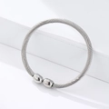 Macro detail of silver twisted rope texture and polished ball ends on magnetic steel bangle - Steel