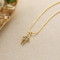 Macro di una collana con ciondolo a forma di ragazzo in oro con zirconi colorati - Marzo Blu Chiaro