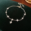 Detailed close-up of a silver zircon flower bracelet on dark green velvet background - Silver