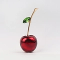 Elegant cherry brooch with red enamel glaze and green crystal leaf on a golden stem - Cherry