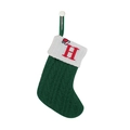 Close-up of green cable-knit Christmas stocking with white cuff and red embroidered letter H - Letter H