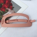 Pink orange matte hollow hair clip for ponytails shown on a white fabric background - Yellow Pink