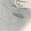 Detail der silbernen hohlen Stern-Haarklammer mit drei Pentagrammen auf blauem Hintergrund - Pentagramme