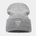 Dettaglio del ricamo a cuore bianco su un berretto grigio in maglia a coste per l'inverno - Grigio