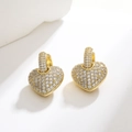 Close-up of golden huggie earrings with heart charms and sparkling pavé cubic zirconia - White