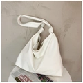 Vista detallada del bolso plisado blanco sobre una superficie de mesa blanca minimalista - Blanco