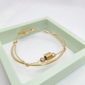 Dettaglio di un bracciale a doppio strato dorato con cilindro a spirale e pietre di zircone - Bracciale Rigido Oro 366 (366 Gold)