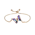 Detailed view of iridescent crystal butterfly charm on a gold-plated slider bracelet - AB Blue