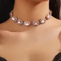 Primo piano di un choker dorato con grandi cristalli rosa e strass bianchi brillanti - Stile Rosa (JXJL21159)