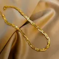 Three-strand braided gold herringbone chain necklace on elegant champagne silk fabric - H200 Triple Twist Braided Chain / Gold