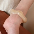 Detail shot of wavy acrylic bangle with cream marble texture worn on wrist - Wave Irregular Bangle / Light Coffee