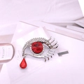 Detail einer silbernen Evil Eye Brosche mit Kristallen und rotem Tropfen-Anhänger - Rot