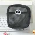 Close-up of a grey mesh pouch with funny big eyes embroidery on a white keyboard - 13*7*13cm / Gray