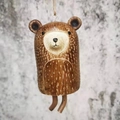 Close-up of a rustic brown resin bear wind chime hanging from a natural jute rope - Raccoon
