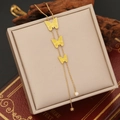 Detailed view of golden butterfly tassel necklace on luxury jewelry box with zircon accents - Yellow