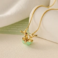 Macro shot of gold rabbit pendant with green shell and sparkling red zircon eyes - Light Green