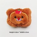 Close-up of small plush bear with apple hat accessory, measuring 4.8cm high and 6.5cm wide - Dark Brown Bear