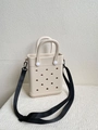 Detail view of beige EVA tote bag featuring perforated holes and black woven shoulder strap - Off-white