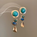 Macro detail of French vintage hollow teardrop earrings with colorful inlaid gemstones - Three Section Gold Green Blue Contrast Vintage Style