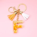 Detail of resin letter F keychain with gold foil flakes and double silk tassels - Letter F