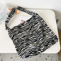 Flat lay of a zebra print canvas tote bag with a wide strap on a clean white background - 9 Black & Beige Zebra Print