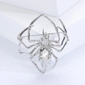 Detailed macro view of a silver spider brooch with a sparkling clear crystal raindrop - Spider / Silver