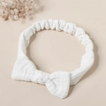 Detail of soft white muslin cotton baby headband with a decorative bow and elastic band - Pure White