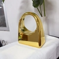 Fashionable gold acrylic evening bag with metallic finish and circular handle design - Gold