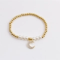Elegante bracciale di perle placcato oro con ciondolo a luna in zircone su sfondo bianco - Luna Curva Dorata-CCB0580