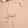 Beaded necklace with silver bow, heart and pink crystal pendants on brown backdrop - Silver