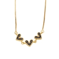 Detail of gold box chain necklace featuring triple heart charms with black stone inlay - Black