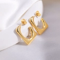 Detailaufnahme goldener quadratischer U-Ohrringe auf eleganter weißer Seide und Keramik - Gold Quadratisch
