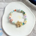 Colorful ceramic bead bracelet with starfish and flower charms on white tray - 1048-02 Ivory Tower