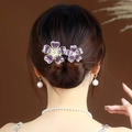 Barrette fleur mauve élégante avec bords dorés et zircon, portée sur un chignon - Fleur d'Améthyste