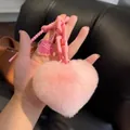 Vue détaillée d'un porte-clés coeur en peluche rose avec fourrure douce et grosse chaîne - Rose Clair