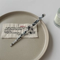 Detailed macro view of black and white marble acetate hair pin with spiral twist design - Black & White