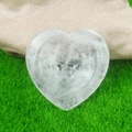 Natural transparent crystal heart worry stone for healing placed on green lawn - White Crystal
