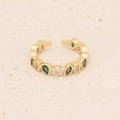 Dettaglio ravvicinato dell'anello dorato regolabile con zirconi verdi e bianchi su sabbia - Stile Zircone Colorato (4#)