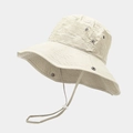 Detail view of beige wide-brim sun hat featuring metal eyelets and adjustable wind rope - One Size / Cream