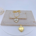 Detail van gouden hartvormige hanger met boze oog motief en zirkonia steentjes - Witte Schelp Hart Oog