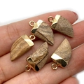 Hand holding five natural stone chili pendants with gold edges in brown texture - 10x20mm / Picture Jasper