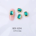 Makro-Detail von smaragdgrünen Nageljuwelen mit goldener Legierung auf rosa Nägeln - 12*12.5mm Smaragdgrün Goldbasis (8294)
