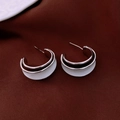 Detail of C-shaped silver earrings with black and white enamel on brown fabric - Silver-White (C-Shape Minimalist)