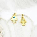 Detail of 18K gold plated Hamsa Hand charms with blue enamel eye on white lace - Hamsa Hand