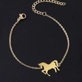Dettaglio di un bracciale dorato con ciondolo a forma di pony e chiusura a moschettone regolabile - Collana / Oro